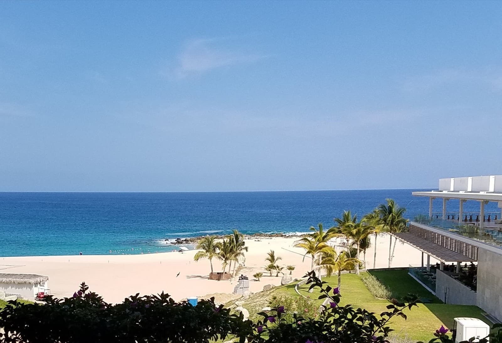 Playa de arena blanca en San José del Cabo con palmeras, jardín y mar azul