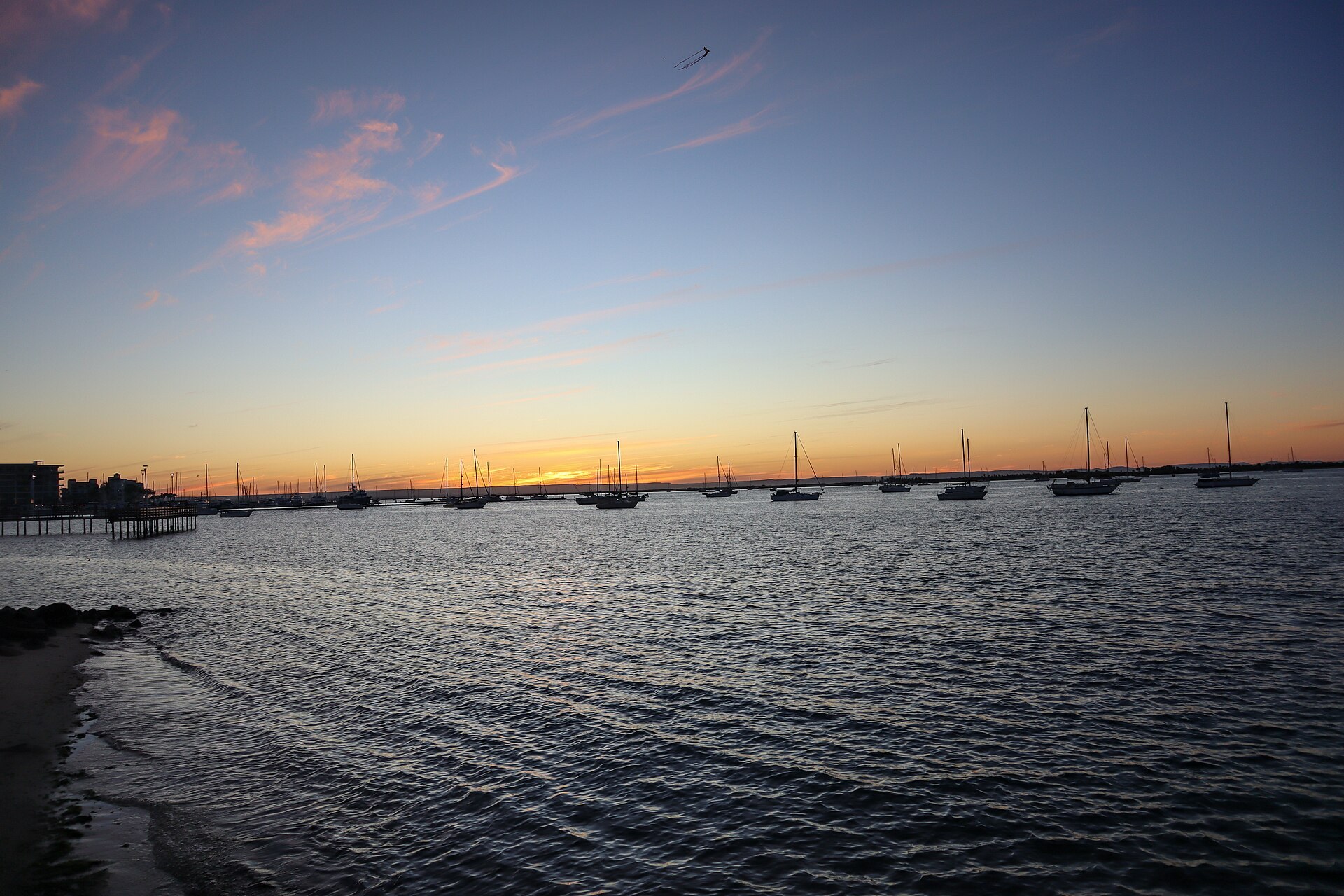Atardecer sobre la bahía de La Paz con veleros anclados frente al malecón